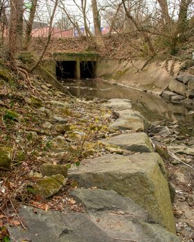 A Dark and Spooky TUnnel in a Shallow Creek in an Autumn Forest