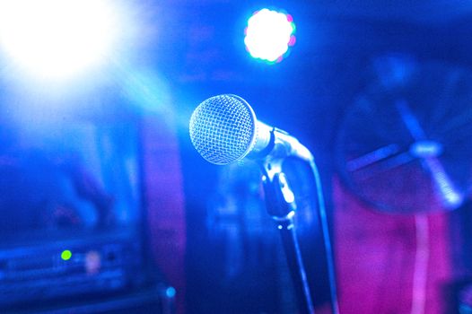 vocal microphone in a set of spotlights on a concert stage in a club