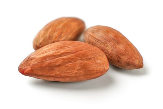 Three almond nut seeds, isolated on white background.