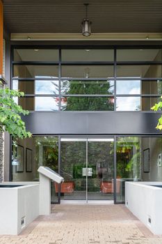 Entrance of new residential building with paved area in front.