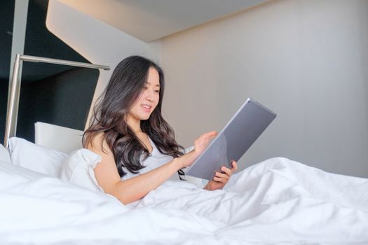 Yound woman using tablet on the bed 