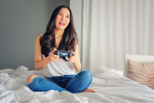 Beautiful girl playing video game on bed