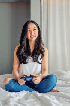 Beautiful girl playing video game on bed