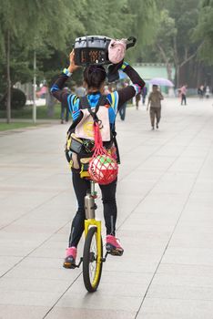 Harbin, Heilongjiang, China - September 2018: Girl driving unicycle outdoors. Girl on the unicycle