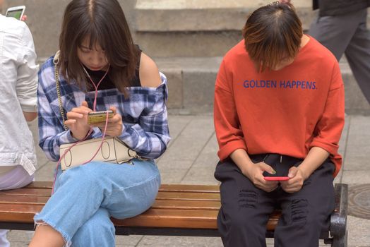 Harbin, Heilongjiang, China - September 2018: Woman using smart phone. Girls look at smartphones. Girl with phone