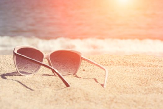 Glasses on the beach sand. Glasses on a background of sea waves