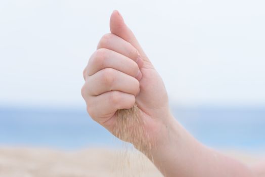 Hand with sand on the beach. Macro snapshot of hand with sand