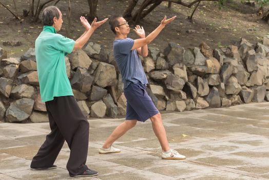 Harbin, Heilongjiang, China - September 2018: Young asian men practicing wushu on the park