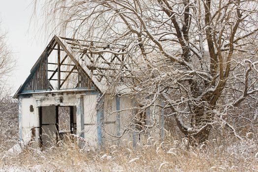 Old abandoned house. Winter landscape with old house