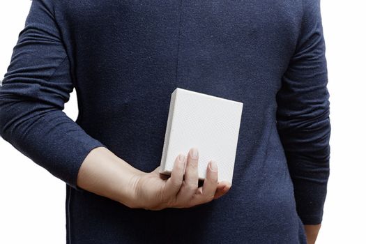 Woman with a gift behind her back on a white background