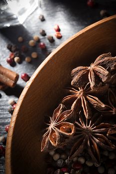 Anise stars and peppercorns in a wooden dish