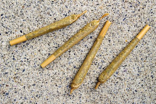 Cannabis Pre-Roll Joints Cigarettes on a concrete texture.