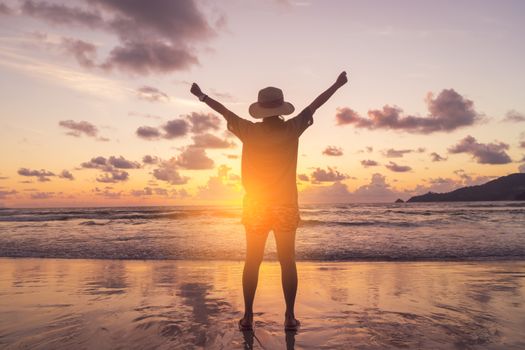 Woman rise hands up to sky freedom concept with sunset sky and summer beach season background.