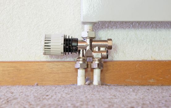 Heating radiator detail with adjusting knob, low to the ground