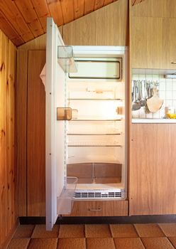 Old open fridge in a dated kitchen