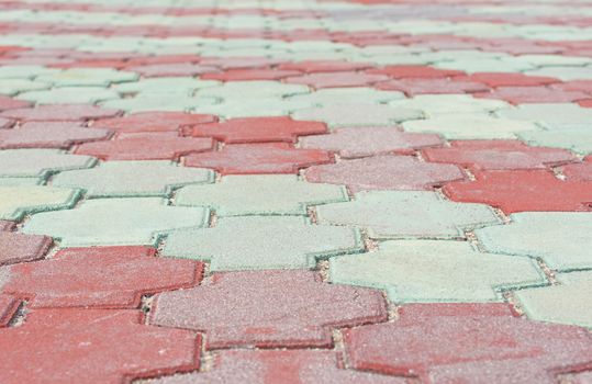 Stone pavement in perspective. Stone pavement texture. Red and green paving stones