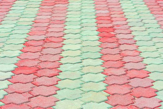 Stone pavement in perspective. Stone pavement texture. Red and green paving stones