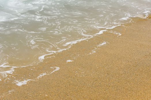 Sand and water. Wave of blue ocean on sandy beach