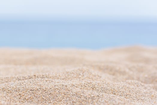 Sea sand and blue sea background. Sandy tropical beach with a blurred sea. Copy space