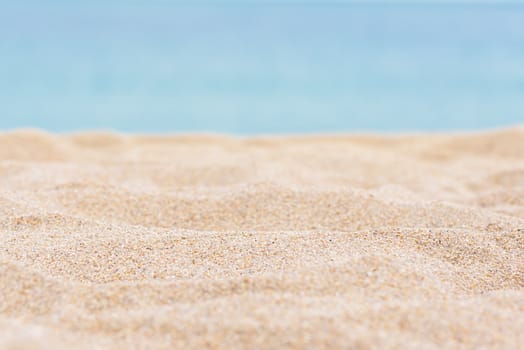 Sea sand and blue sea background. Sandy tropical beach with a blurred sea