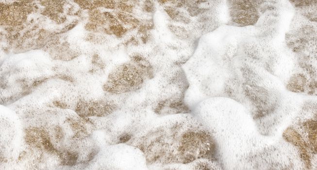 Sea foam in the sand. Splashes of sea waves