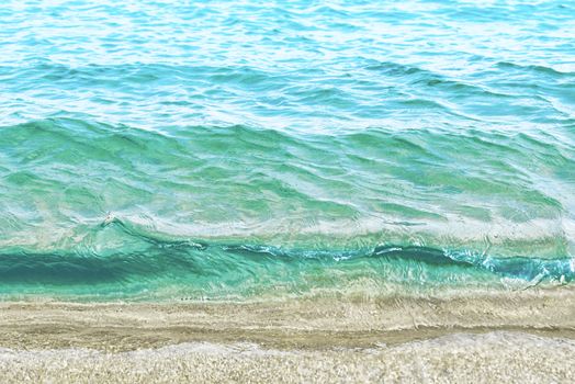 Wave of blue sea on sandy beach. Sea surface background.