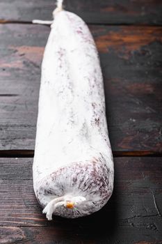 Traditional spanish dry longaniza sausage on wooden background.