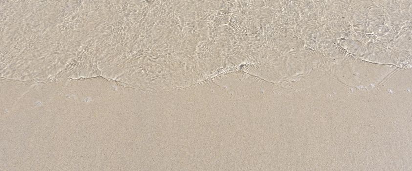 Sand texture. Sandy beach for background. Soft wave of the sea on the sandy beach