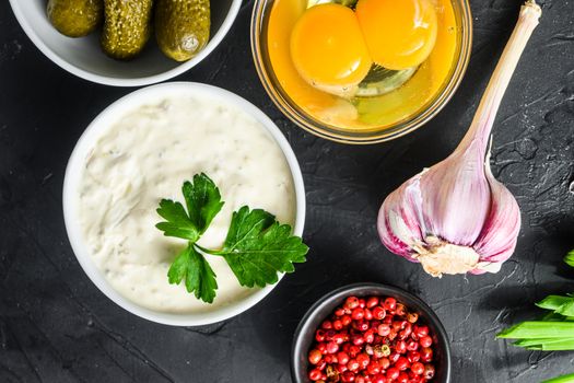 Organic lemon ranch dressing in a small jar with fresh greens. Tartar sauce. Making sauce from capers, cucumbers, parsley, lemon and eggs. For fish and chips and sea food top view close up.