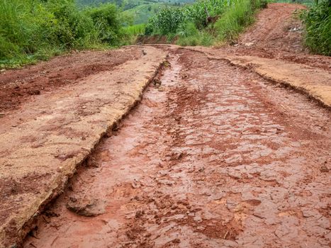 Gravel road with mud in countryside.