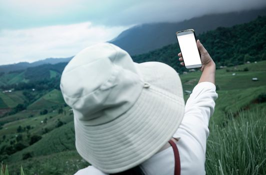 Tourist enjoy nature and take pictures with smartphone on the mountain background.