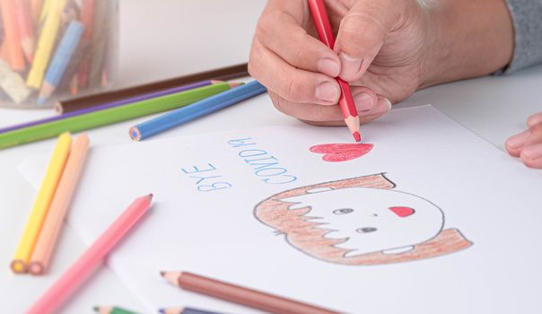 Close-up of a hand painted with color pencil, depiction of smiling girl showing goodbye to the Coronavirus.