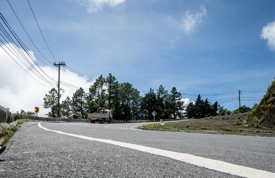 Asphalt road with the truck drives up the hill.