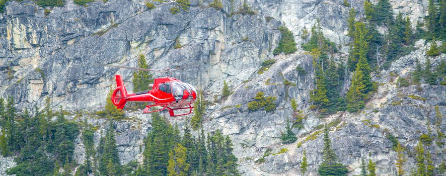 Red Helicopter rescueing wounded people in the mountain scenario
