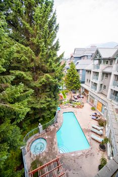 WHISTLER, CANADA - AUGUST 11, 2017: Beautiful hotel with pool under the mountains.