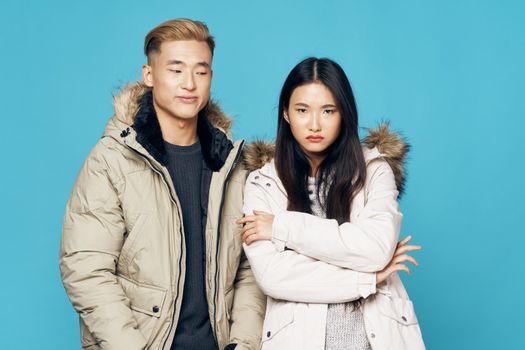 Man and woman in winter jackets Asian appearance fashion coolness lifestyle blue background