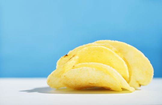 Potato chips or crisps on colored background ,beautiful slices of fried potatoes 