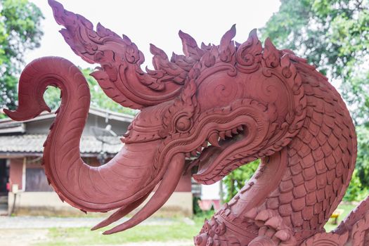 Dragon, scorpionfish, Wat Sila Ngu with the red temple Wat Ratchathammaram on Koh Samui in Thailand.