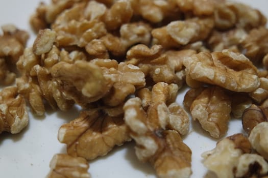 Close-up top view of peeled walnut on a white background. peeled walnut without shell ready to eat dry fruit.