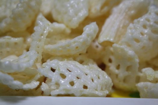 Closeup view of freshly fried chips as fast food for tea break. Potato chips with spices sprinkled on it. Fast food background for advertisements.