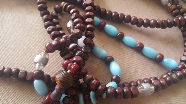 Beautiful wooden prayer beads or rosary placed over fabric background. Religion concept of ramadan or Eid for muslims.