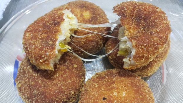 Closeup view of fried pizza bomb or pizza balls with dripping cheese. Pizza bombs are delicious and tasty altered form of pizza.
