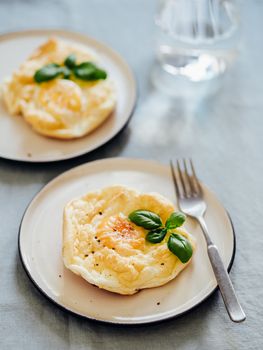 Fluffy Cloud Eggs. Trendy food - oven bake scrambled eggs with whipped egg white and whole yolk on plate Vertical.