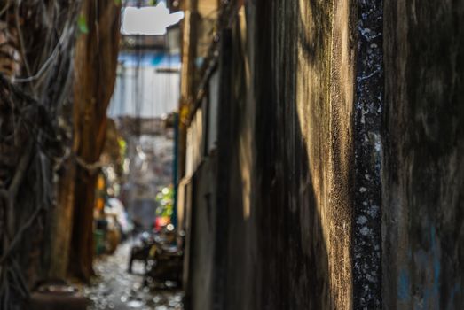 The light that shines down at the wall of narrow street in the old village. Archaeological area. Focus and blur.