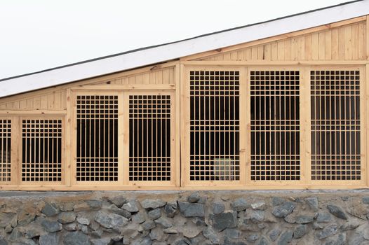 Wooden house wall. Wooden lattice on the window.