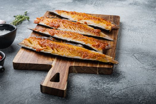 Marinated scomber fillet with paprika and saffron on grey background.