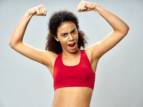 Sportive woman holds hands above head bodybuilder workout motivation