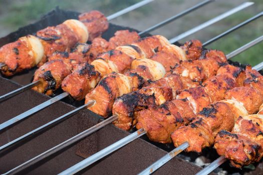 Photo cooking fry shish kebab,BBQ, barbecue, shashlik or meat on coals. Cooking meat in the grill on skewers in nature in the summer on a picnic. Pork on the grill