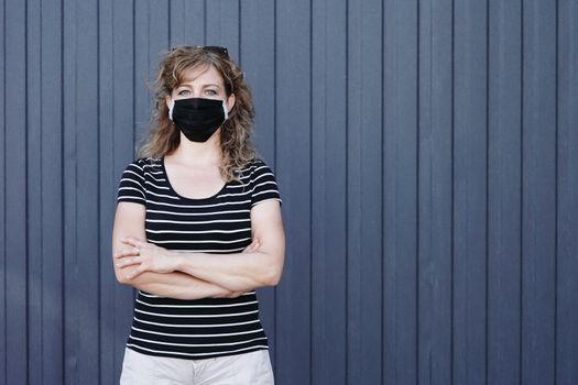 Portrait of a Girl in a protective mask free space for an inscription. Social distancing. Blue striped wall in the background