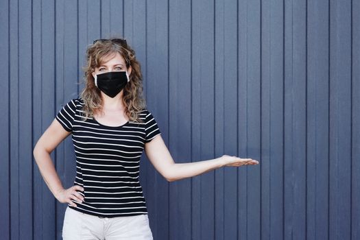 Portrait of a Girl in a protective mask free space for an inscription. Social distancing. Blue striped wall in the background